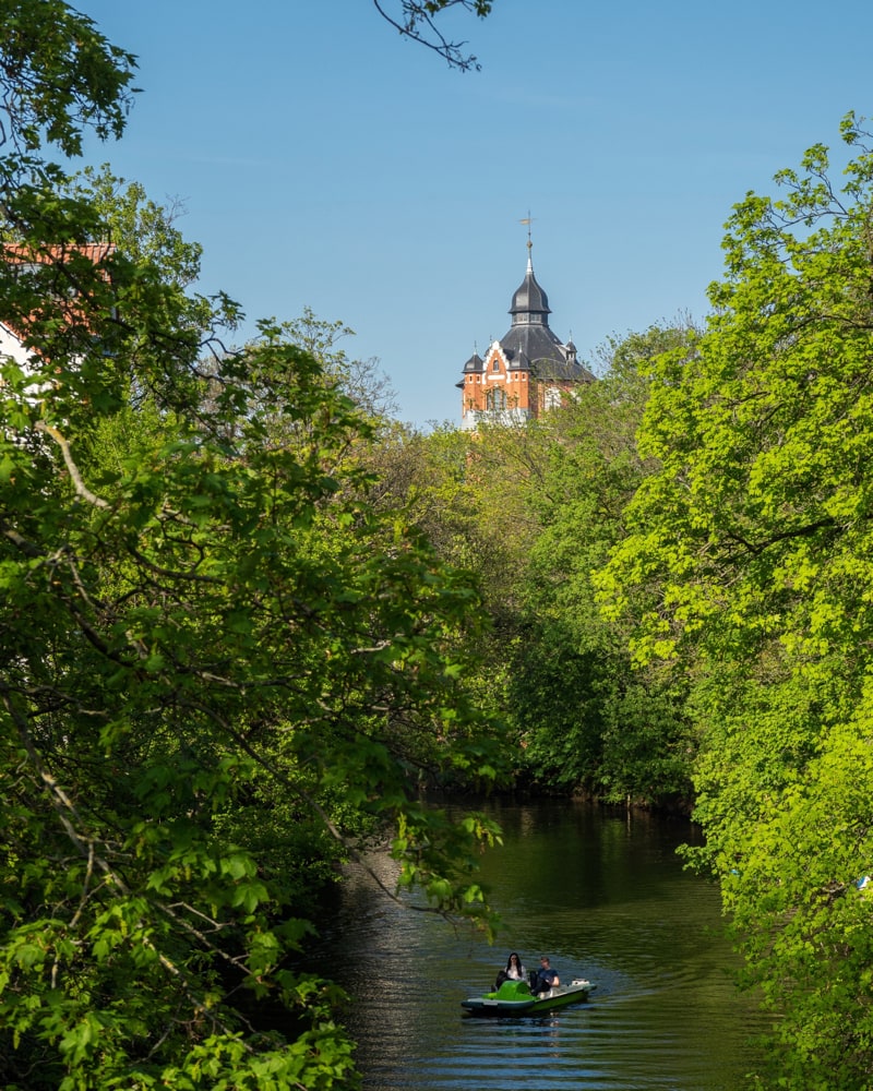 A couple uses a pedal boat on the Oker in front of an old water tower