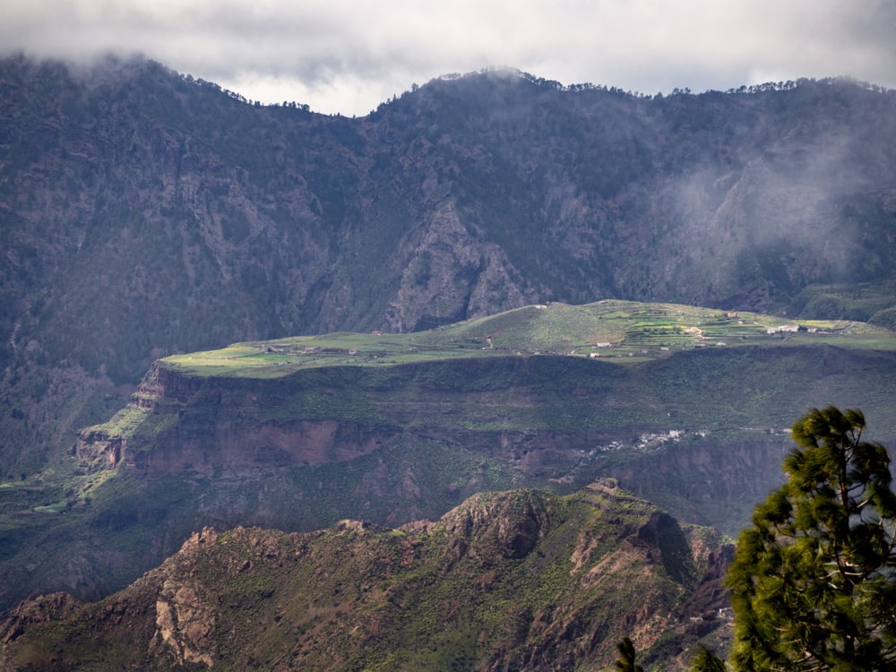 Patches of light hit the plateau of Acusa Verde while thick clouds roll above it