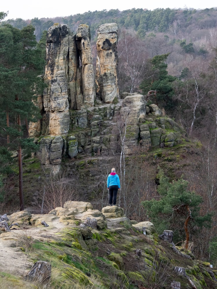 A female hiker (my wife) standing on a cliff looking at a rock formation