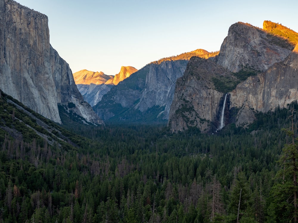 Tunnel view down the Yosemite Valley as the top of Half Dome is lit by the setting sun.