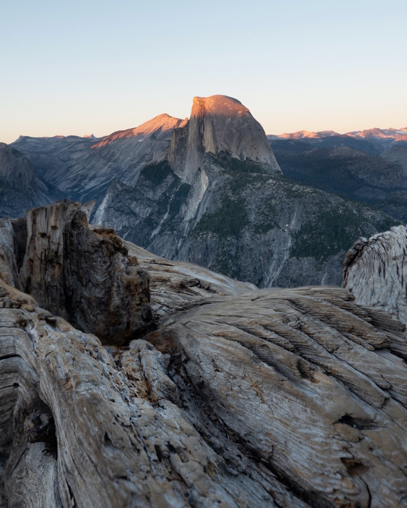 View of Half Dome from Glacier Point top of Half Dome is lit by the setting sun.